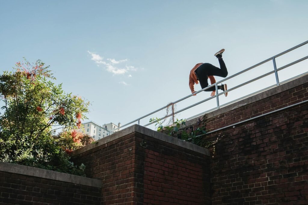 fearless unrecognizable man jumping over railing