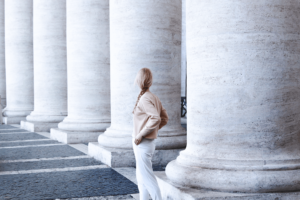 photo of woman standing beside concrete pillar